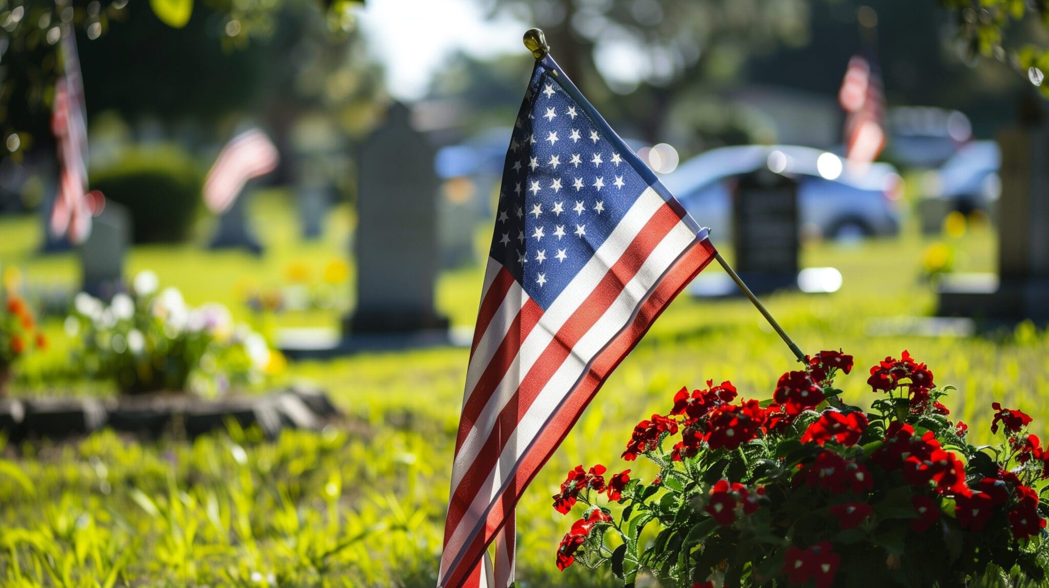 At a military cemetery on Memorial Day, an American flag flies majestically against a backdrop of numerous white gravestones. Cemetery
